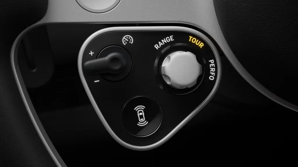 Close-up of a satellite control pod on the Ferrari Luce steering wheel, with a physical dial and toggle switch